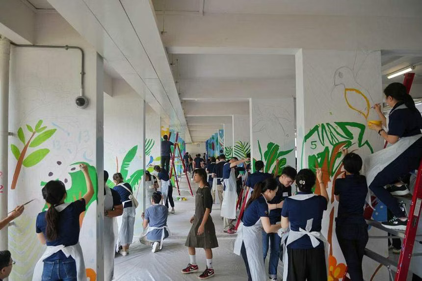 Temasek staff painting botany-themed murals at a void deck to enliven the HDB rental block in Clementi during Community Day on June 25.