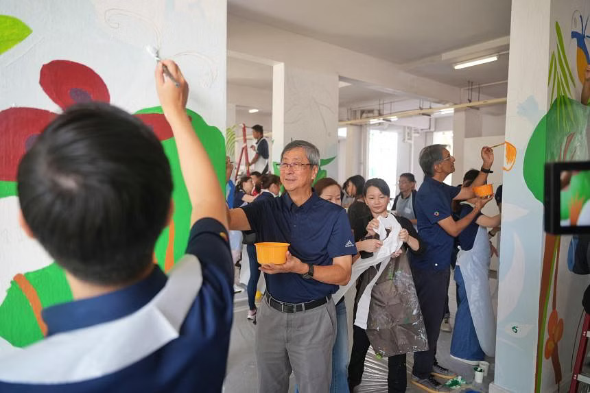 Temasek Holdings chairman Lim Boon Heng (left) and CEO Dilhan Pillay painting murals during the company's annual Community Day on June 25.